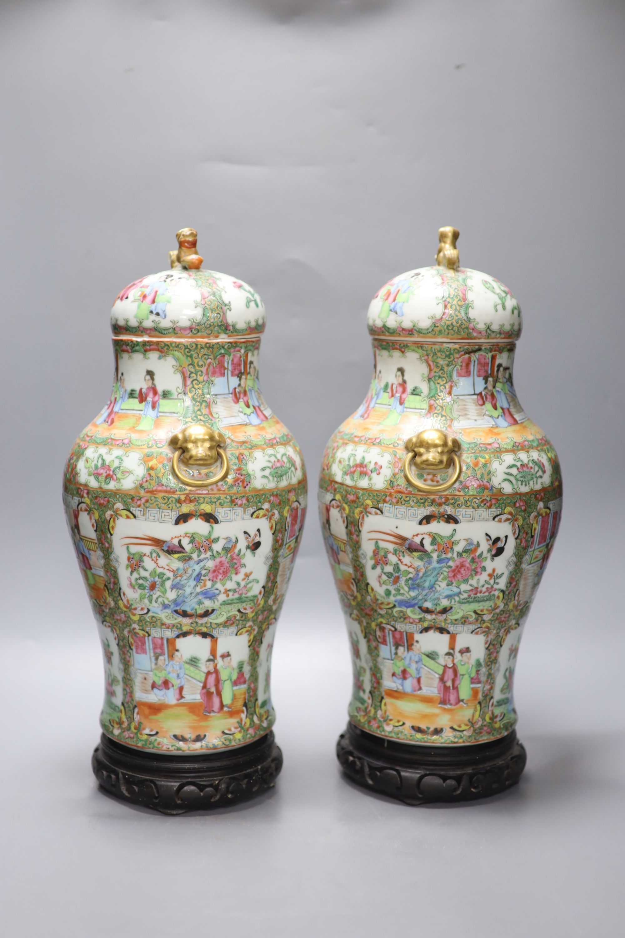 A pair of 19th century Cantonese vases and covers, with later stands, overall height 44cm (a.f.)